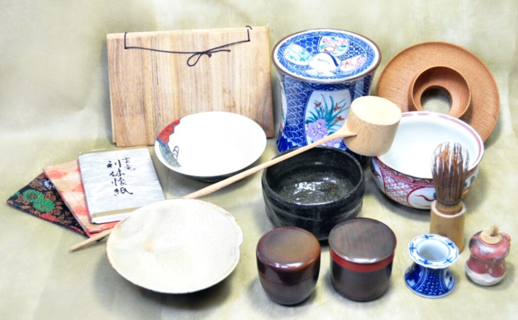 茶碗、棗、茶筅、柄杓、水指、共箱などの茶道具一式が丁寧に並べられている。証明書や風呂敷も添えられ、査定や買取時に重要な付属品が揃っている様子が分かる。